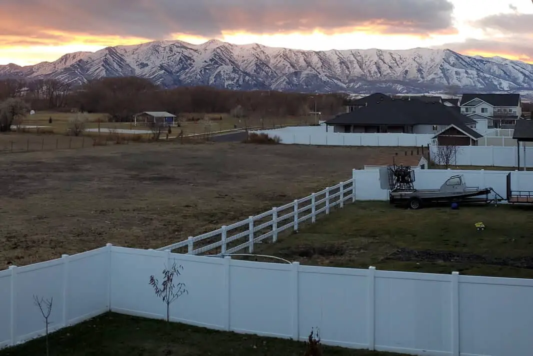 view-of-multiple-backyard-vinyl-fences-mountains-in-background